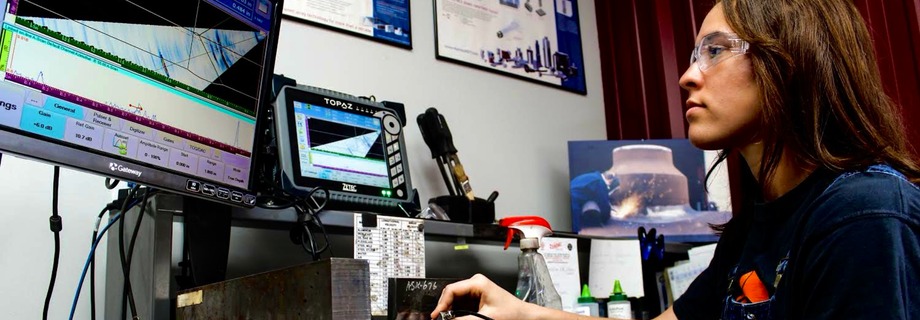 Prüferin bei der Ultraschallprüfung (Phased Array) mit Sonde und Bildschirm